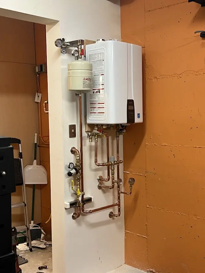 Plumbing technician inspecting water heater connections in Piscataway